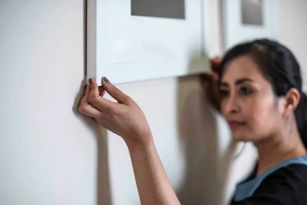 Folk positioning painting on the wall