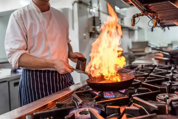 Chef cooking a dish on a frying pan
